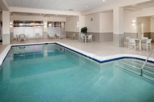 a pool in a hotel with tables and chairs at Embassy Suites by Hilton Laredo in Laredo