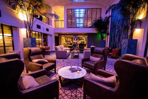 a lobby with couches and chairs and a table at Hotel Theodore Seattle Downtown, Tapestry by Hilton in Seattle