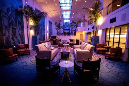 a lobby with couches and tables in a building at Hotel Theodore Seattle Downtown, Tapestry by Hilton in Seattle
