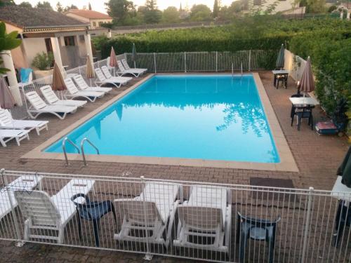 einen großen Pool mit Stühlen und einem Tisch in der Unterkunft Hôtel Restaurant Douce France in Saint Alban Auriolles