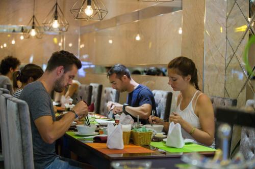 a group of people sitting at a table in a restaurant at Ambassador Hanoi Hotel & Spa in Hanoi