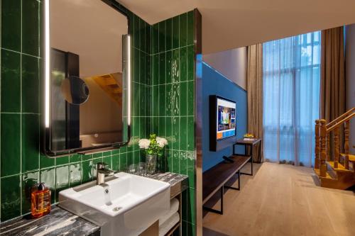 ein Badezimmer mit Waschbecken und Spiegel in der Unterkunft Orange Hotel, Beijing Daxing Biomedicine Base in Peking