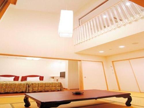 a living room with a bed and a coffee table at Sunshine Shirako New in Shirako