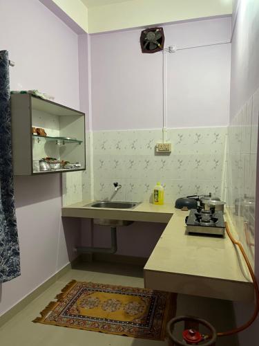 a kitchen with a sink and a counter top at Puhor Inn in Sivasagar
