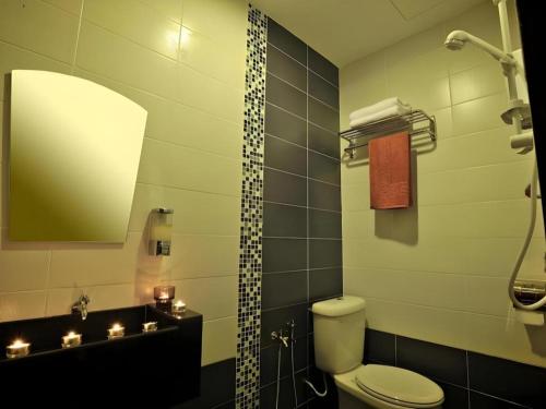 a bathroom with a toilet and a sink and a mirror at Sea Lion Hotel @ Klang in Kampong Telok Gadong Besar