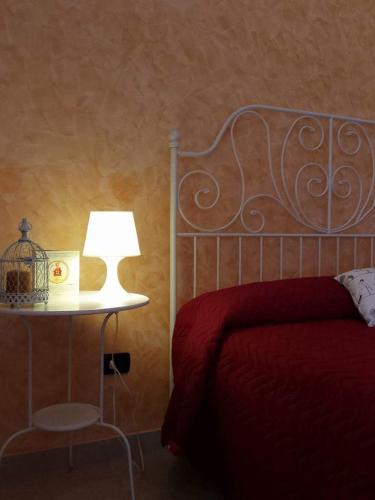 a bedroom with a bed and a table with a lamp at La Casa di Ninna Affittacamere in Ariano Irpino