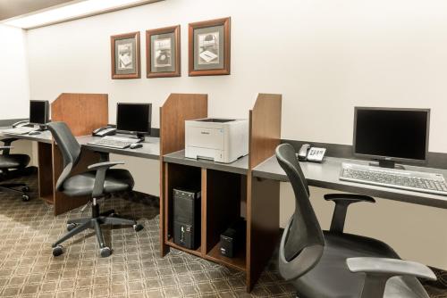 an office with two desks with computers and chairs at Ramada by Wyndham Olds in Olds