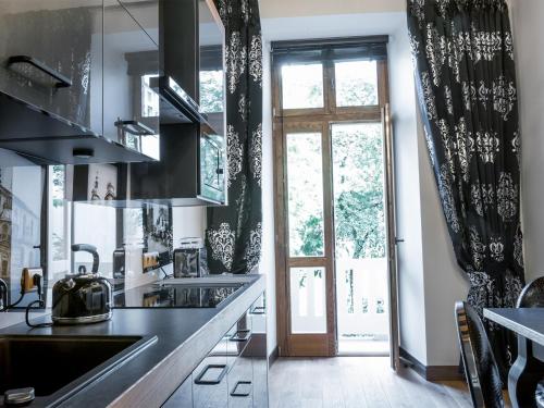a kitchen with black and white drapes and a window at Leonardo 2 in Kraków