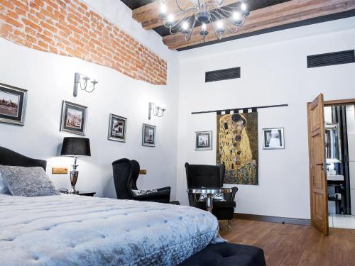 a bedroom with a bed and two chairs at Leonardo 2 in Kraków