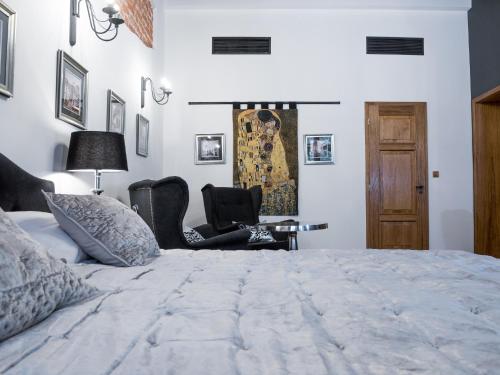 a bedroom with a large bed and two chairs at Leonardo 2 in Kraków