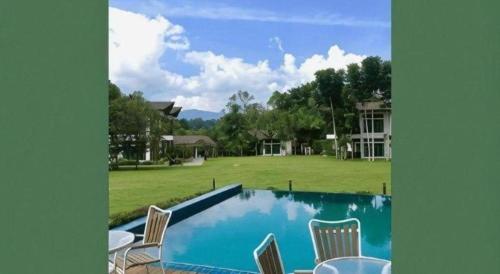 a large swimming pool with chairs and a yard at Bidaisari Resort in Kampong Sum Sum
