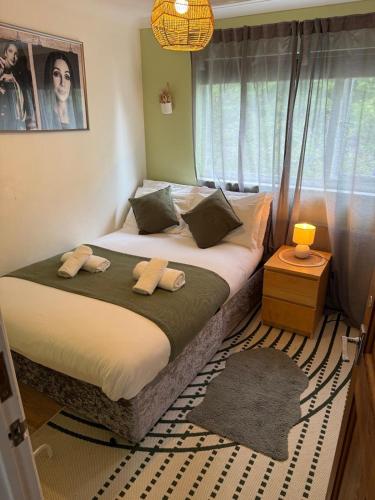 a bedroom with a large bed with a window at Flamingo Short Lets Greenleys in Wolverton
