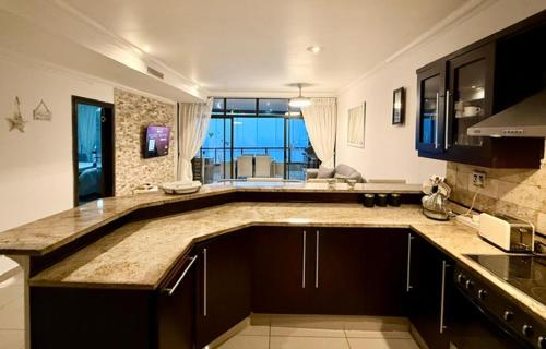 une cuisine avec un grand îlot au milieu dans l'établissement Coral Reef 502, à La Mercy