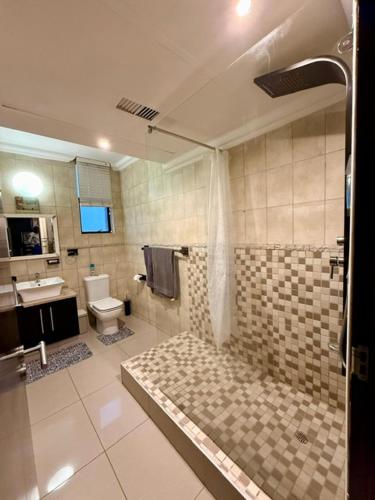 a bathroom with a shower and a toilet and a sink at Coral Reef 502 in La Mercy
