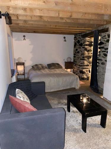 a bedroom with a bed and a couch and a table at Chalet coeur d'alpage La Plagne Les Arcs in La Plagne Tarentaise