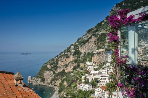 a view of the amalfi coast with purple flowers at Hotel Villa Franca in Positano