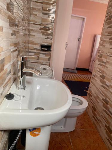 een badkamer met een wastafel en een toilet bij Lajoy Executive Lodge in Lusaka