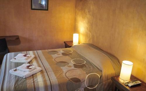 Habitación con 1 cama con 2 toallas y 2 luces en Posada Cobodemar en Mar de Cobo