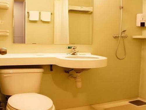 a bathroom with a sink and a toilet and a mirror at Jinjiang Inn Yantai Fushan District Fuhai Road in Yantai