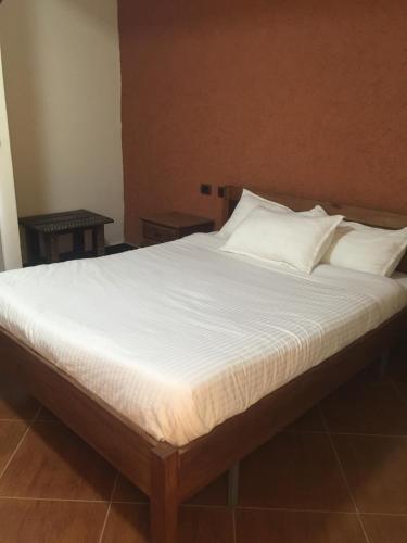 a bed with white sheets and pillows in a room at Harbe Hotel in Lalībela
