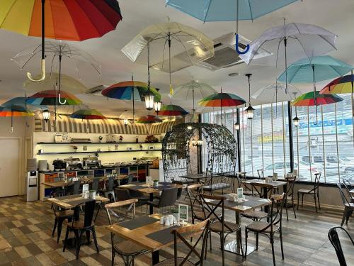 un restaurant avec des tables et des parasols suspendus au plafond dans l'établissement Tempo Suites Airport, à Istanbul