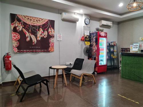 un magasin avec des chaises, une table et un distributeur de soda dans l'établissement De Chukai Hotel, à Cukai