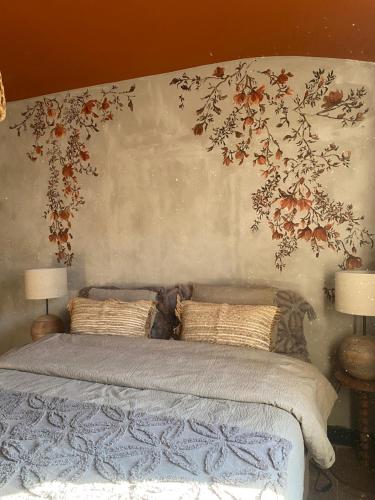 a bedroom with a bed with flowers on the wall at Dreamhome B&B Limoux in Limoux
