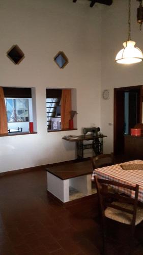 a living room with a table and two windows at Artenatura BeB in Terranuova Bracciolini