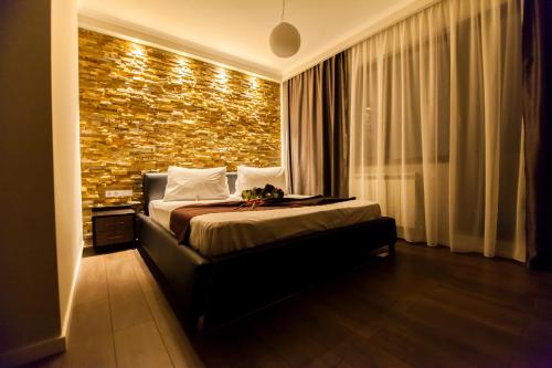 a bedroom with a bed and a brick wall at Cluj Business Class in Cluj-Napoca