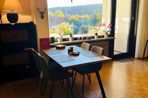 Una mesa de comedor con sillas y una gran ventana. en Ferienwohnung Bergblick, en Bad Harzburg