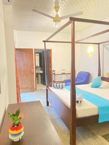 a bedroom with two bunk beds and a table at Sea Front Hikkaduwa in Hikkaduwa
