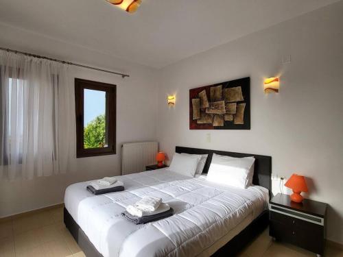 une chambre avec un grand lit avec deux serviettes dessus dans l'établissement villa agnanti 'Despoina' with private pool, à Skouloúfia
