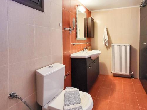 une salle de bain avec des toilettes blanches et un lavabo dans l'établissement villa agnanti 'Despoina' with private pool, à Skouloúfia