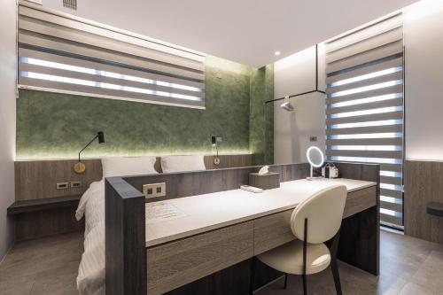 a bedroom with a desk with a chair and a bed at Triple Suite Villa BnB in Magong