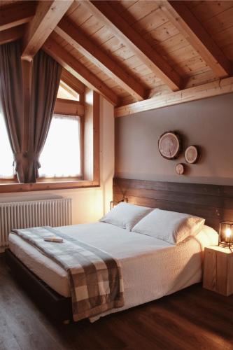 a bedroom with a large bed in a room with wooden ceilings at SAN ROMEDIO Agriturismo in Romeno