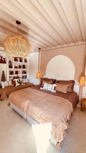 a bedroom with a large bed and a large chandelier at Riad Origines in Marrakesh