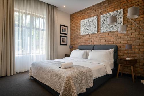 a bedroom with a bed and a brick wall at Iconyc Apartment in Brentwood Park