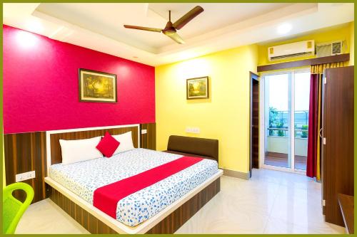 Un dormitorio con una cama y una pared roja. en Jagannath Temple Shashi Palace Resort - Fully Air conditioned# Free Wifi And Room Service #Budget Class Best Hotel IN Puri, en Puri