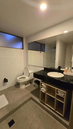 a bathroom with a sink and a toilet and a mirror at Hotel Confort 80 Zona Rosa By Hoteles Confort80 in Bogotá