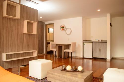 un salon avec une table et une cuisine dans l'établissement Hotel Confort 80 Zona Rosa By Hoteles Confort80, à Bogotá