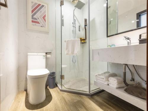 ein Badezimmer mit Toilette und Glasdusche in der Unterkunft Borrman Hotel Guangzhou East Station Meihuayuan Subway Station Branch in Guangzhou