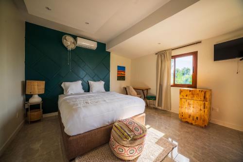 una camera da letto con un letto grande con una parete verde di Résidence Kazela a Chirongui