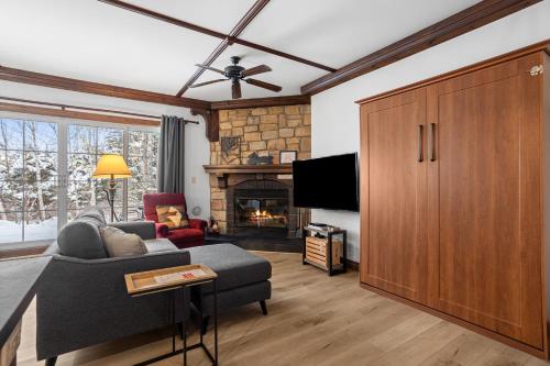 ein Wohnzimmer mit Sofa und Fernseher in der Unterkunft Les Manoirs Wpool & Hot Tub Near Village 120-7 in Mont-Tremblant