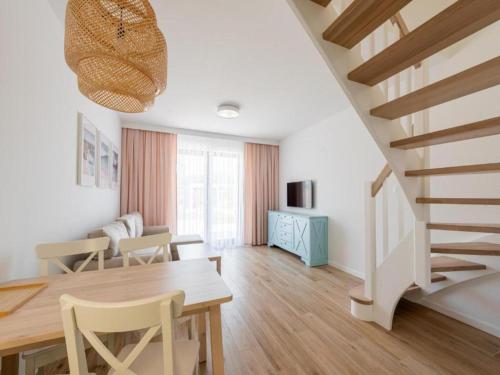 - un salon avec une table à manger et un escalier dans l'établissement Holiday house for 4 people, peace and quiet, à Grzybowo