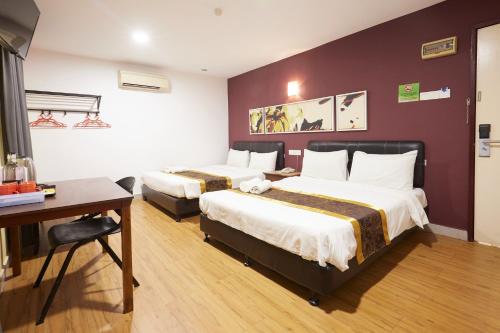 a hotel room with two beds and a desk at Hotel Sunjoy9 OKR Near Midvalley 10 Mins Only in Kuala Lumpur
