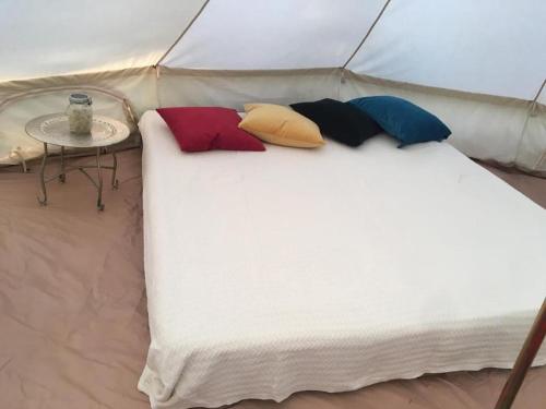 - un lit dans une tente avec 4 oreillers dans l'établissement Zeltferien Into The Wäid Zelt Unter Der Esche, à Ennetmoos