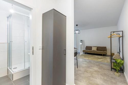 ein Badezimmer mit einer Glasschiebetür und einem Spiegel in der Unterkunft Jomi Stays Steglitz in Berlin