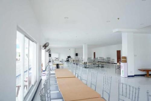 Großes weißes Zimmer mit Stühlen und Tischen in der Unterkunft Palazio De Laiya Resort Hotel in San Juan