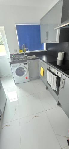 a kitchen with a sink and a washing machine at Welcome to Home away from home in Southampton