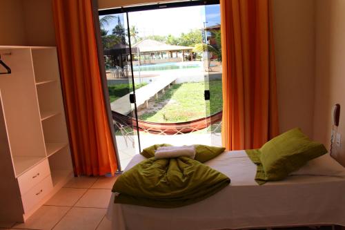 Hotel Real Comandatuba في إلها دي كومانداتوبا: غرفة نوم بسرير ونافذة كبيرة